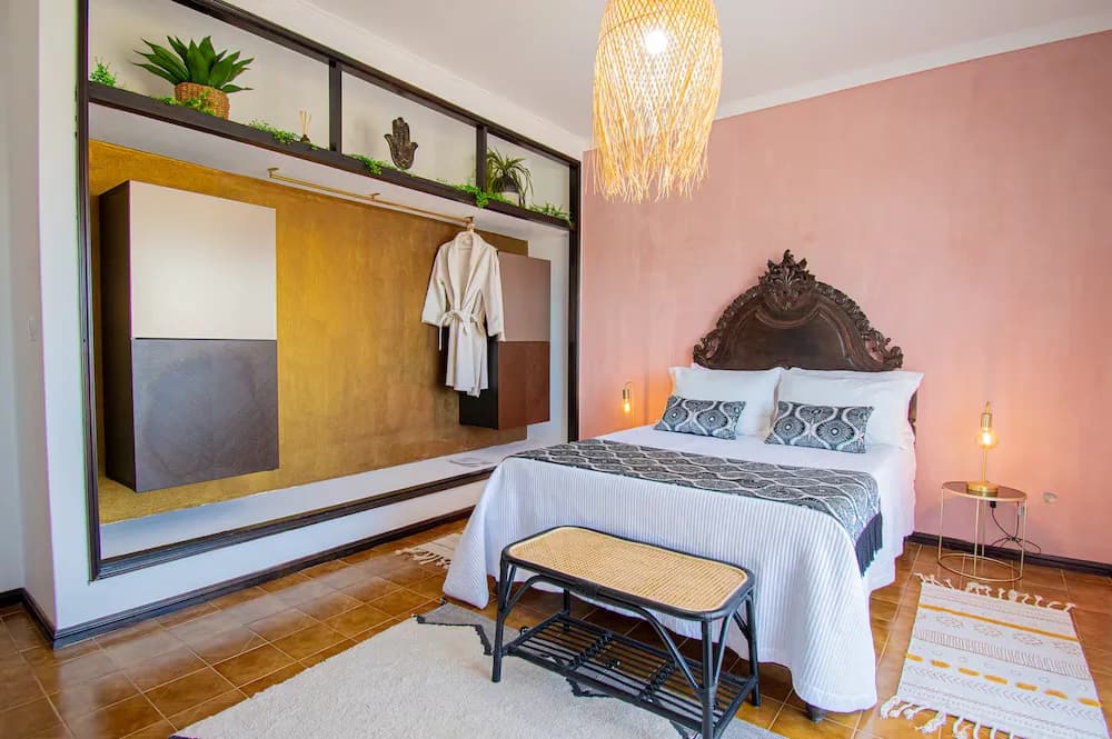Camera spaziosa con testiera decorativa e pareti rosa