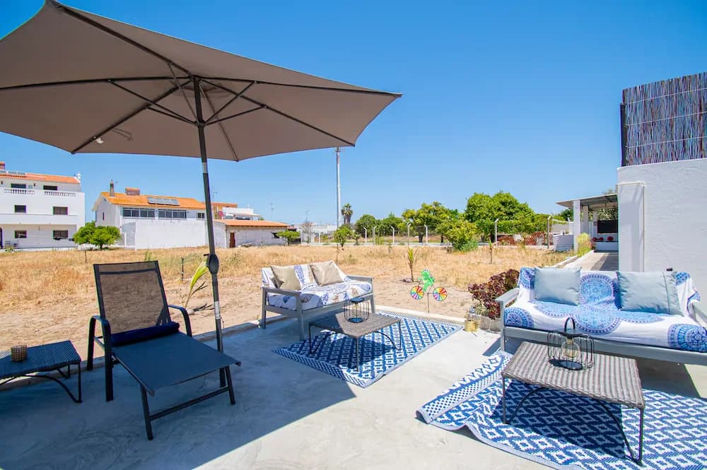 Area relax esterna con divani e ombrellone