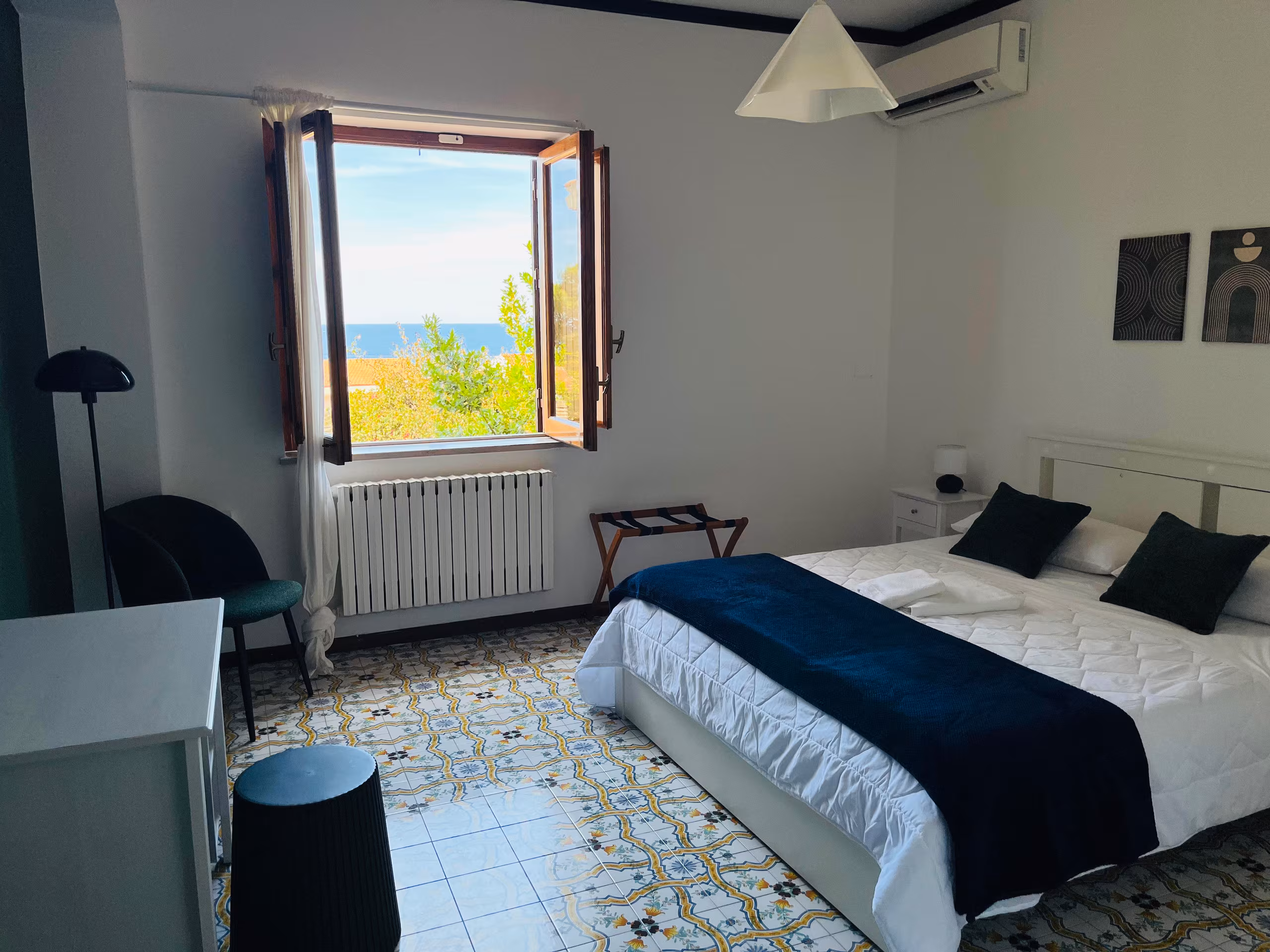 Camera con letto matrimoniale, pavimento in maiolica e finestra sul mare