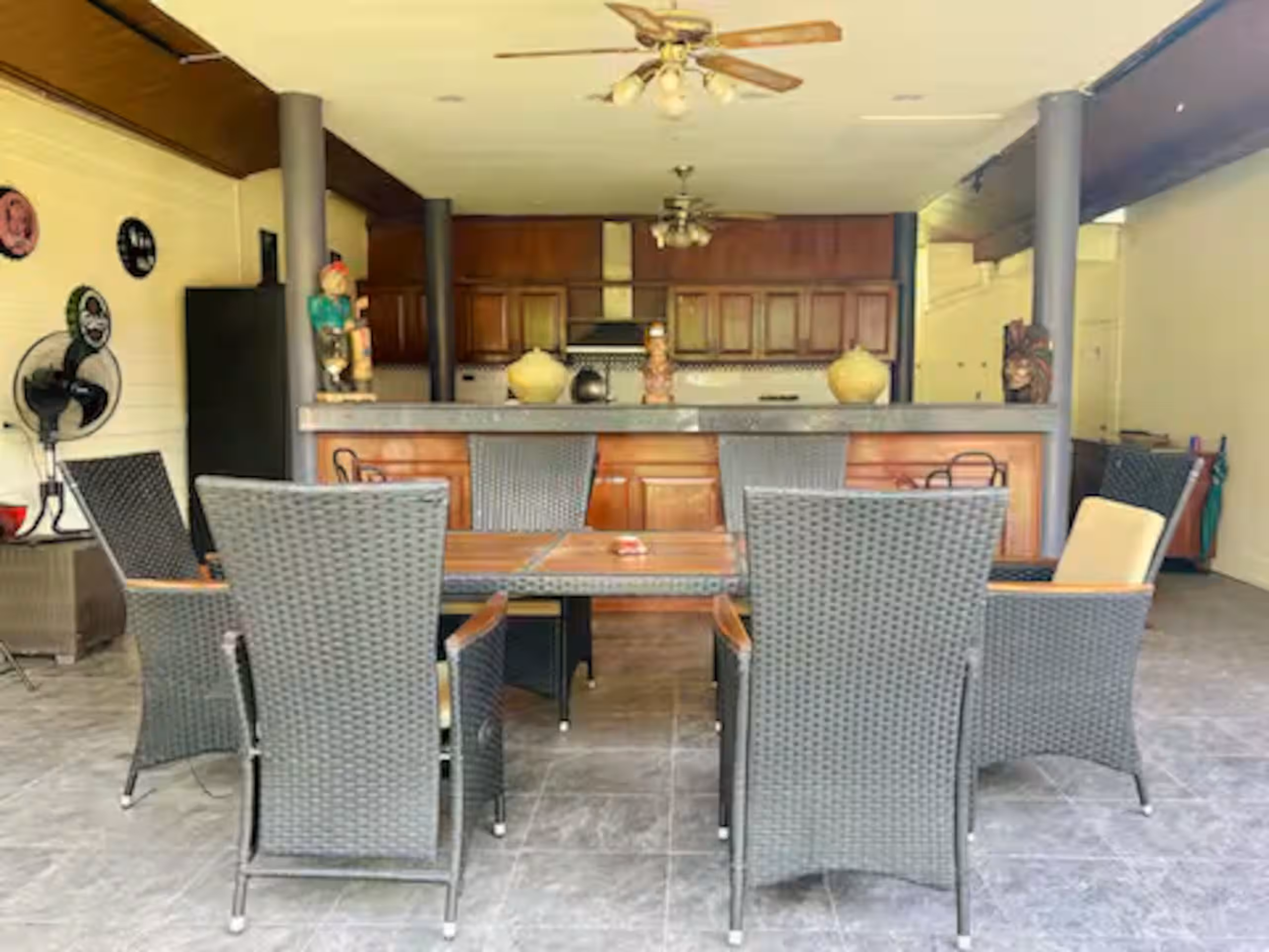 Zona living esterna coperta con tavolo da pranzo e cucina